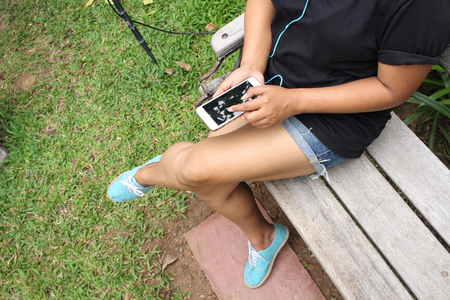Woman listening to music on earphone with smart phoneの写真素材