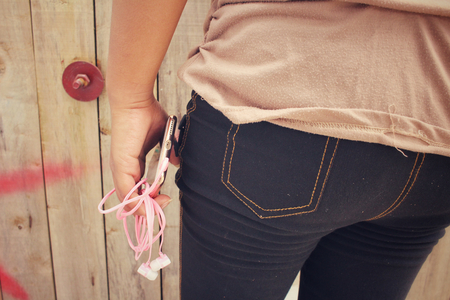 Woman listening to music on earphone with smart phoneの写真素材