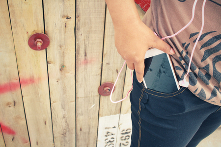 Woman listening to music on earphone with smart phoneの写真素材