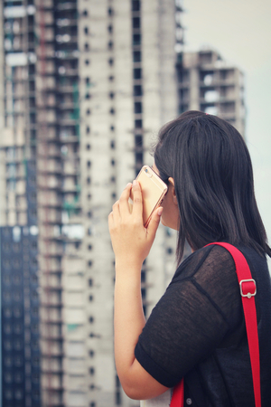 Woman using smart phone with cityの写真素材