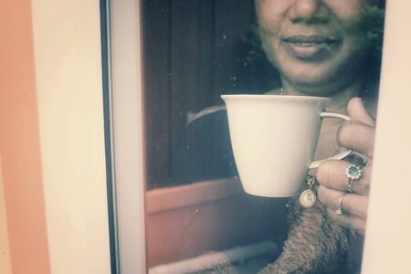 Senior drinking coffee with windowの写真素材