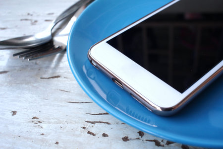 fork and spoon with smart phoneの写真素材