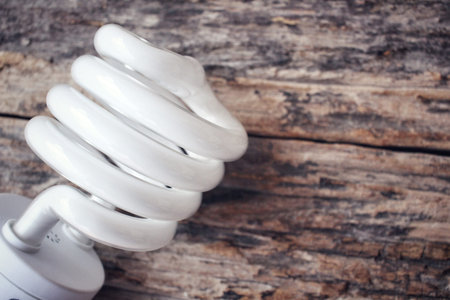 Energy saving lamp on the wood backgroundの写真素材