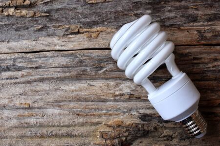 Energy saving lamp on the wood backgroundの写真素材