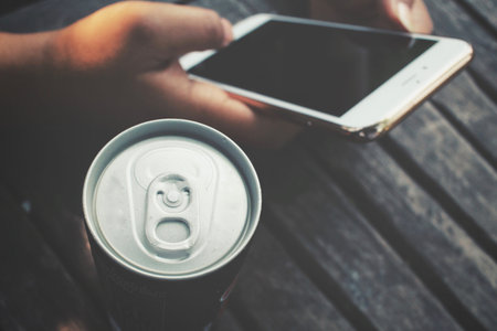 Woman using smart phone with aluminum canの写真素材