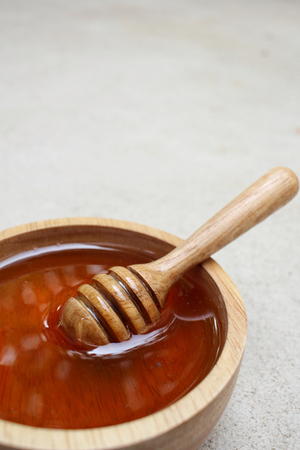 Fresh honey with honey dipperの写真素材