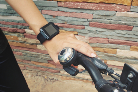 Woman riding bicycle with smartwatchの写真素材