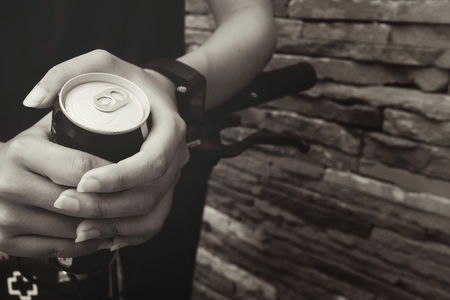 Woman drinking cola can with bikeの写真素材