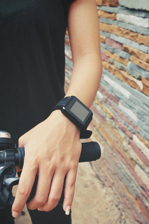 Woman riding bicycle with smartwatchの写真素材