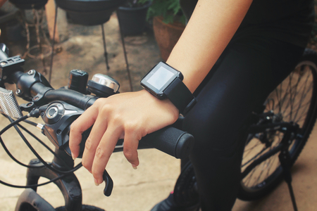 Woman riding bicycle with smartwatchの写真素材