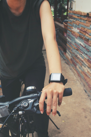 Woman riding bicycle with smartwatchの写真素材
