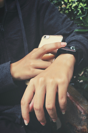Woman using smartwatch with smart phoneの写真素材