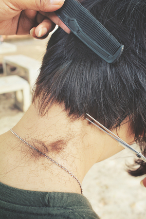 Hairdresser cutting hair with scissorsの写真素材