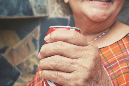 Senior drinking cola canの写真素材