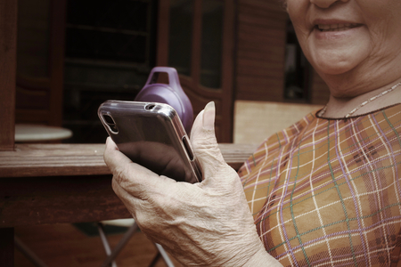 Senior woman using bluetooth speaker with smart phoneの写真素材