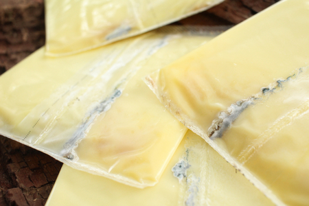 Slices of american cheese with moldの写真素材