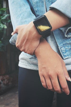 Smartwatch on hand with jeans jacketの写真素材