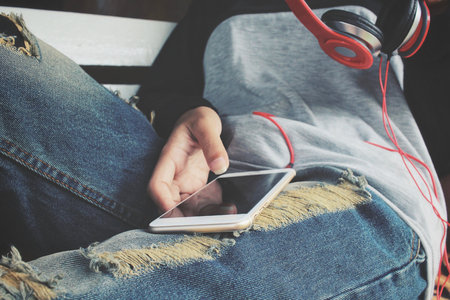 Woman listen to music on headphones with smart phoneの写真素材