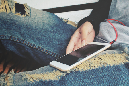Woman listen to music on headphones with smart phoneの写真素材