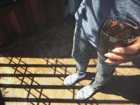 Cola with ice cubes on hand