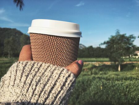 Selfie of coffee paper cup on handの写真素材