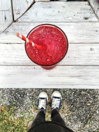 Selfie of shoes with red beverageの写真素材