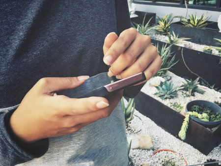 Woman using smart phone in garden