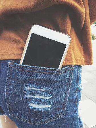 Smart phone in jeans pocketの写真素材