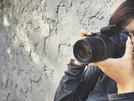Woman using a camera to take photoの写真素材