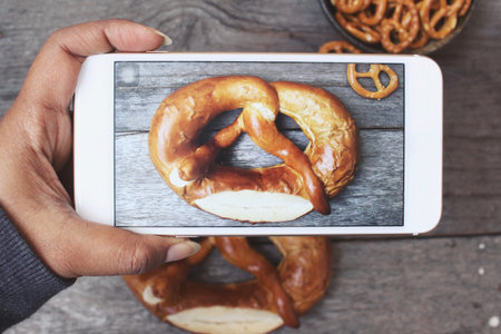 Taking a photo of pretzels with smart phoneの写真素材