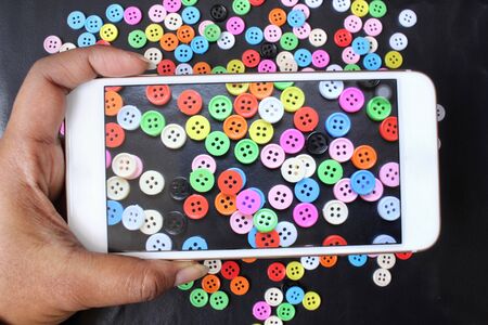 Taking a photo of sewing buttons with smart phoneの写真素材