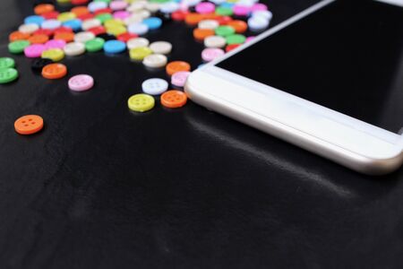 Sewing buttons with smart phoneの写真素材