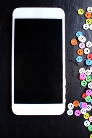 Sewing buttons with smart phoneの写真素材