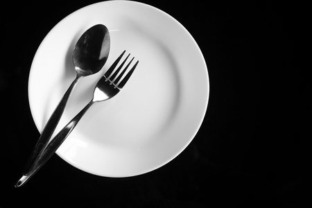 Empty dish with spoon and forkの写真素材