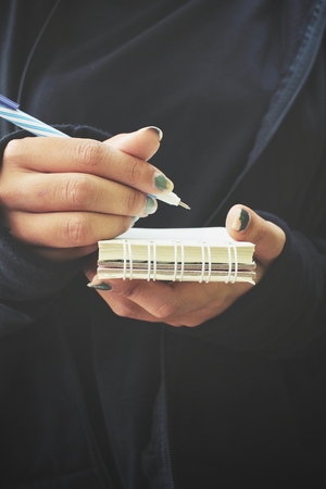 Woman with pen writing on paperの写真素材