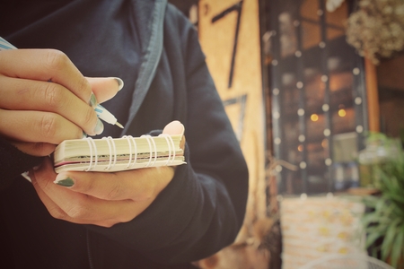 Woman with pen writing on paperの写真素材