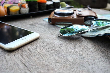 Travel accessories of smart phone map camera and sushi japaneseの写真素材