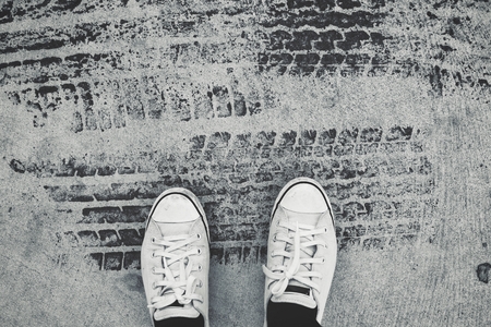 Selfie of shoes with wheel tracks on roadの写真素材
