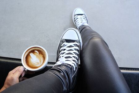 Selfie of shoes with coffee cupの写真素材