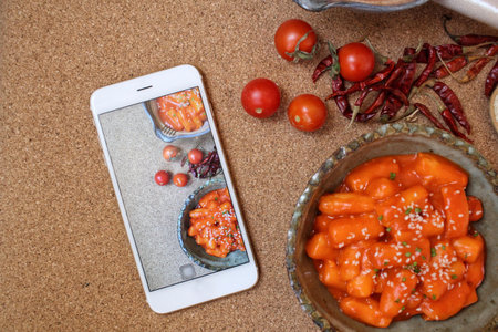 Taking a photo of rice cake korean food with smart phoneの写真素材