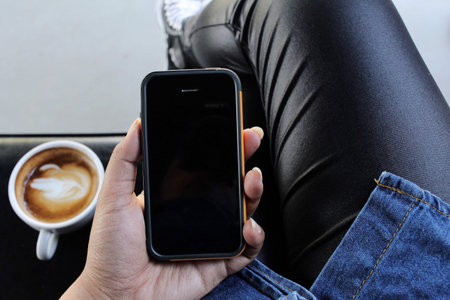 Woman drinking coffee with smart phone