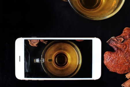 Taking a photo of ganoderma lucidum tea with smart phoneの写真素材