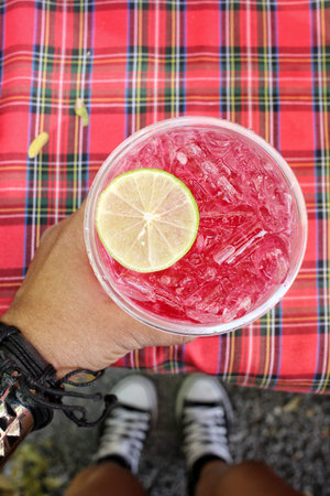 Selfie of red beverage with hand
