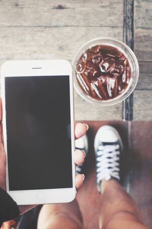 Selfie of woman using smart phone with iced coffeeの写真素材