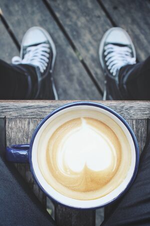 Selfie of coffee cup with handの写真素材