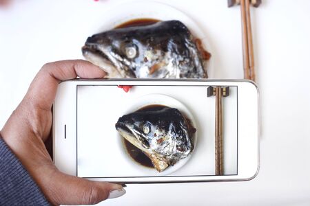 Taking a photo of salmon fish japanese food with smart phoneの写真素材