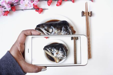 Taking a photo of salmon fish japanese food with smart phoneの写真素材