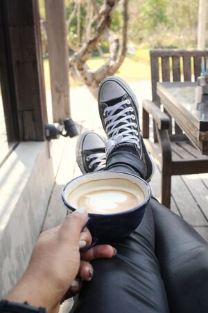 Selfie of coffee cup with handの写真素材