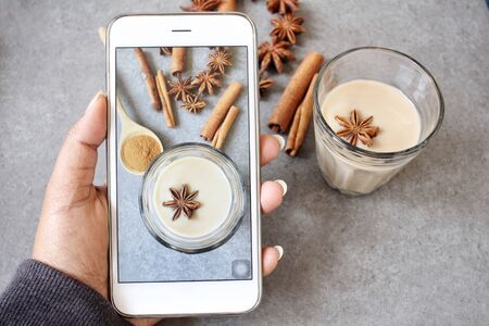 Taking a photo of masala chai with smart phoneの写真素材