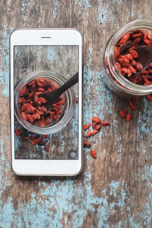 Taking a photo of dried goji berries with smart phoneの写真素材